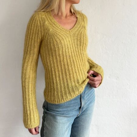 Kvinde iført Cascade Blouse af Odd Row i gul. Smuk V-hals bluse i Highland & Silk Mohair fra Isager med rib og feminine snoninger.