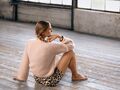 ryggen af model sidder paa gulv ifoert den strikkede cardigan hannah fra filcolana