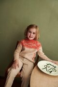 lille pige ifoert little joha sweater fra other loops sweateren er beige og roed