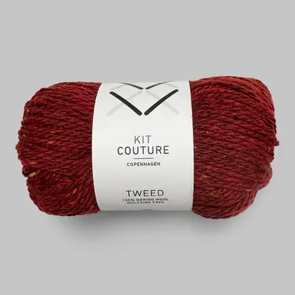 Nøgle af Kit Couture Tweed garn i farven Rubinrød 503, dyb rød merinould med tweednister i varme og gyldne nuancer.