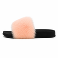 Alt tag: Bløde pels slippers i ferskenfarve med sort sål – komfortable fluffy slides til dame på hvid baggrund