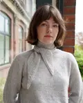 Model iført Strikket Sandoy tørklæde fra kit couture. Strikket i cashmere farven lys grå garn fra kit couture
