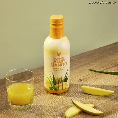 Forever Aloe Mango i glas og mangoskiver og Aloe vera på bord