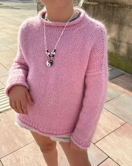 Barn iført Cloud Sweater Junior fra PetiteKnit – blød børnesweater strikket oppefra og ned