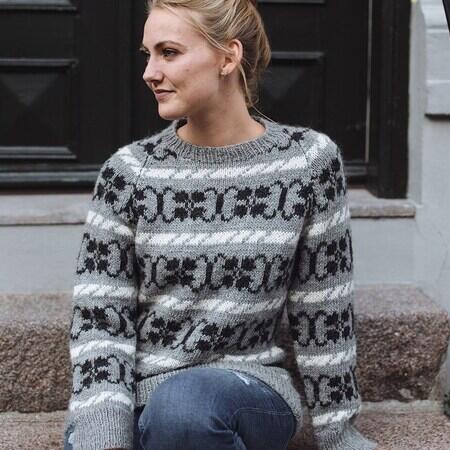 kvinde på trappe iført klematis sweater fra camarose strikket i grå, hvid og sort lamauld