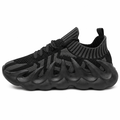 Sort futuristisk sneaker med bølget chunky sål på hvid baggrund