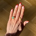 Sara wearing Endless Waves ring made in 925 pure sterling silver plated with 18 carat gold plating with a green zirconia.