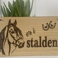 staldskilt i trae med hest og teksten er i stalden
