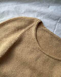 Close up af kumulus tee o-necki paa en seng strikket i pure silk knitting for olive garn