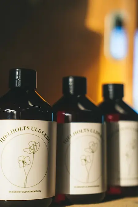 tre flasker hjelholt uldsaebe paa raekke