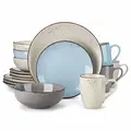 Et keramisk spisestel med lyseblå og beige stykker med plettede accenter. Sættet inkluderer tallerkener, skåle og krus, arrangeret i et display.