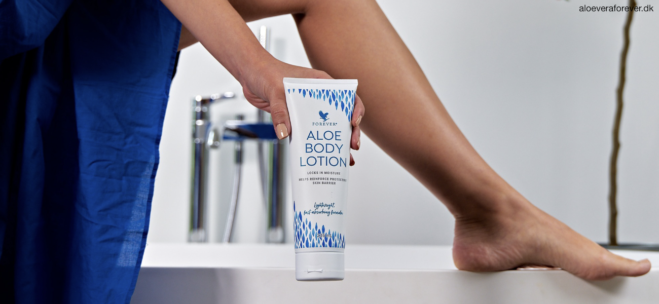 Kvinde med Aloe Body Lotion viser tube og ben