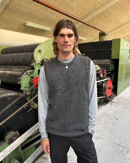 modellen staar paa hjelholt uldspinderi ifoert novice slipover man strikket af petiteknit i dansk pelsuld 5,5/2 fra hjelholt