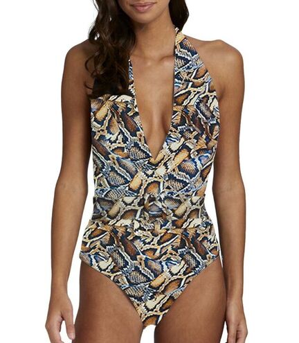 En kvinde iført en badedragt med dyb V-udskæring og et abstrakt, flerfarvet mønster med dyreprint. Billedet er beskåret ved skuldrene og lårene.