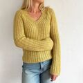 Cascade Blouse af Odd Row vist på model. Strikket i gul Isager Highland & Silk Mohair med ribstruktur, V-hals og lange ærmer.