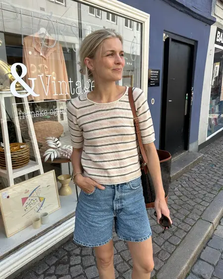 Model iført Amelie tee fra PetiteKnit – strikket t-shirt i Merci fra filcolana i farvene fersken, grå og råhvid