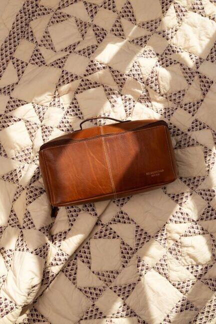 RE:DESIGNED Project 104 i Walnut – læder projekttaske til strik placeret på quiltet tæppe, elegant og rummelig projekt organizer