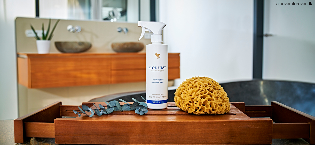 Aloe First førstehjælpsspray står på badeværelse med en svamp ved siden af
