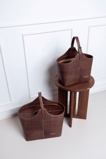 Project 72 læderkurv i farven Woodsmoke fra RE:Designed – to kurve vist i interiørmiljø, én på gulv og én på træbord.