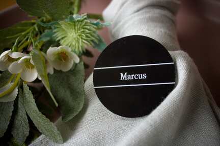 Rundt sort bordkort i akryl med hvid skrift