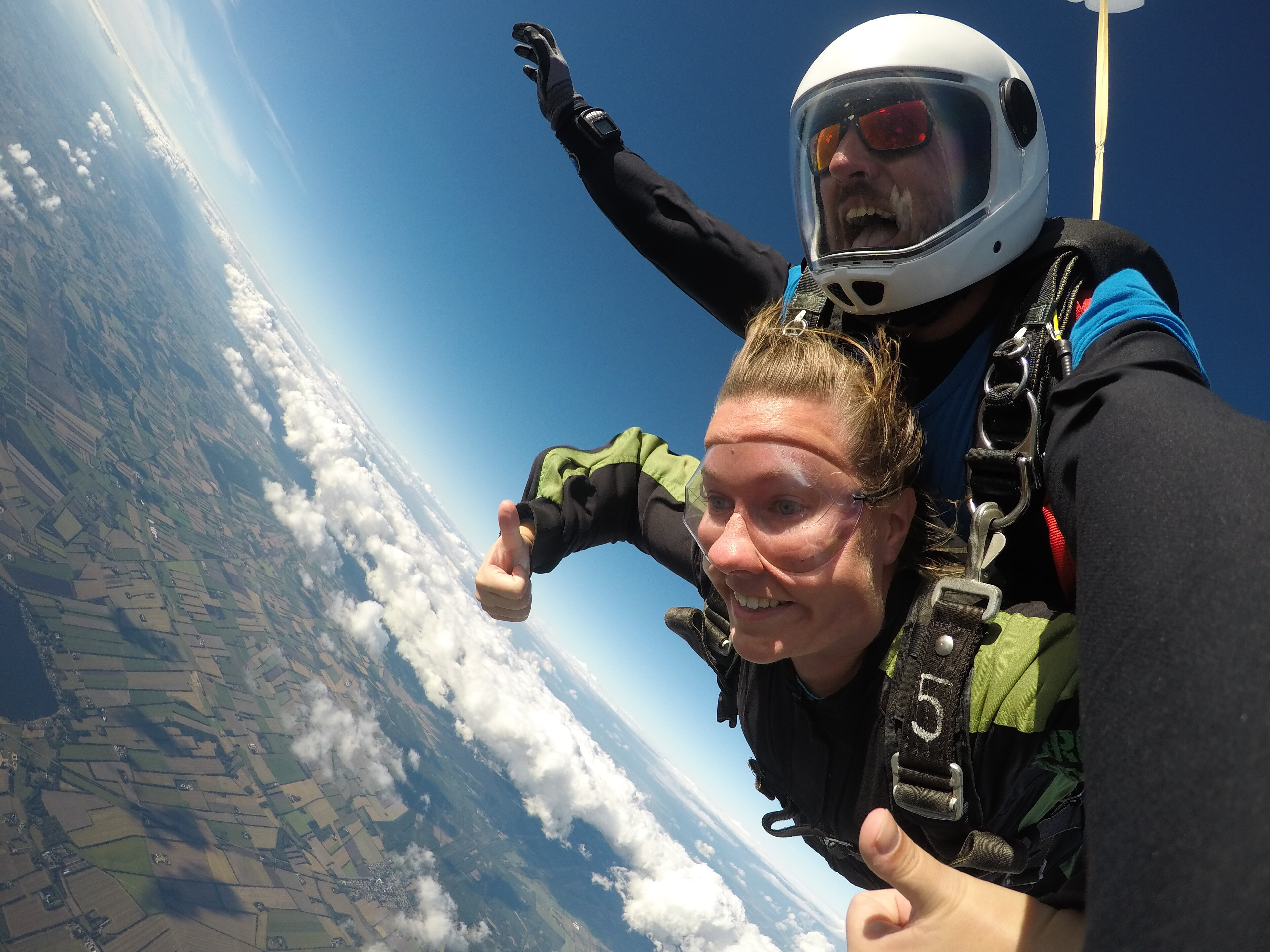 En glad pige giver tommel op i et tandemspring hos Dropzone Denmark