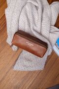 etuiet project 41 fra re-designed i laeder og farven walnut ligger paa et haandklaede