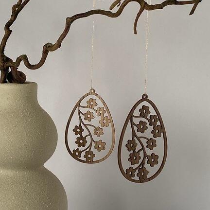 Påskeæg i træ ophængt på gren – nordisk påskepynt og forårsdekoration