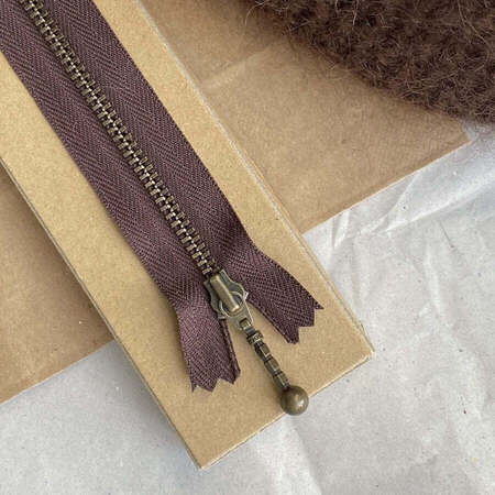 chokoladebrun petiteknit zipper 17 cm på bord