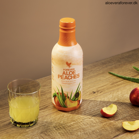 Forever Aloe Peaches - Aloe vera drik med fersken PET flaske på bord med glas