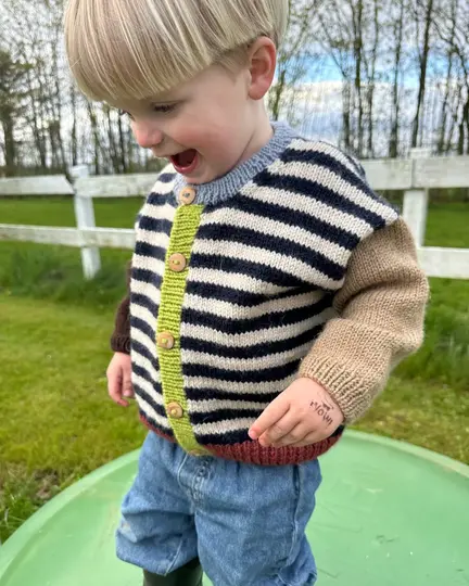 Barn iført Holger Cardigan fra PetiteKnit – stribet strikket cardigan til børn med farverige detaljer