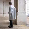 Ryggen af model i Anne Ventzels Cardi Cocoon sølvgrå udgave, strikket i garnet Saga og Tilia