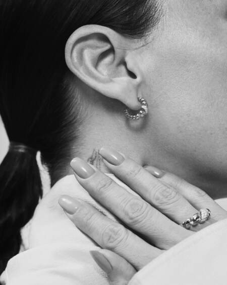 Medina wearing SWIRL W. TOPAZ ring in silver with white topaz.