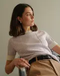 Siddende Kvinde iført stribet anholt strik t-shirt fra kit couture strikket i wool cotton