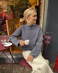Frankie Sweater – klassisk stribet sweater, strikket oppefra og ned, bæres på café.