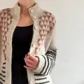 Model iført Alice Jacket fra Isager Archives 2 med åben front, trekantmønster i gammelrosa, beige bundfarve og sorte striber på ærmerne.