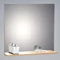 Et minimalistisk spejl på en lys hylde med en moka-gryde, to tomme glas og et lille hvidt fad med orange piller placeret i højre side. Baggrunden er en almindelig grå væg.