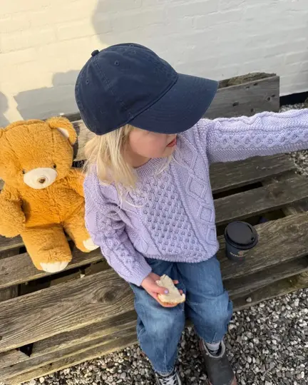 Barn iført Dagmar Sweater Junior fra PetiteKnit strikket i Peer Gynt – sweater i strukturstrik