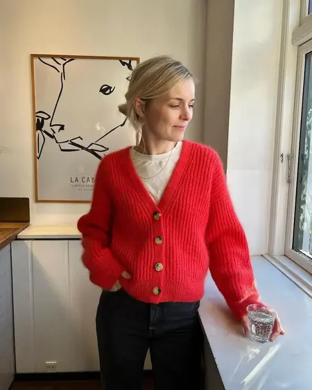 petiteknit ved vindue i sin strikkede roede agnete cardigan