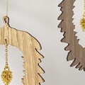 Detalje af gylden kogle vedhæng i juleornament i træ med kæde