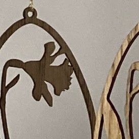 Detalje af laserskåret påskeæg i træ med påskelilje