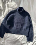 esther sweater model paa sengen petiteknit strikket i blaa version