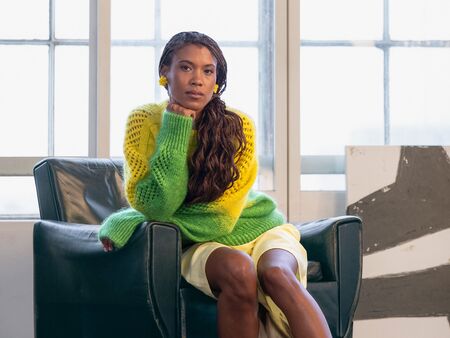 Model sidder i stol iført den strikkede sweater 'birds of a feather' fra filcolana