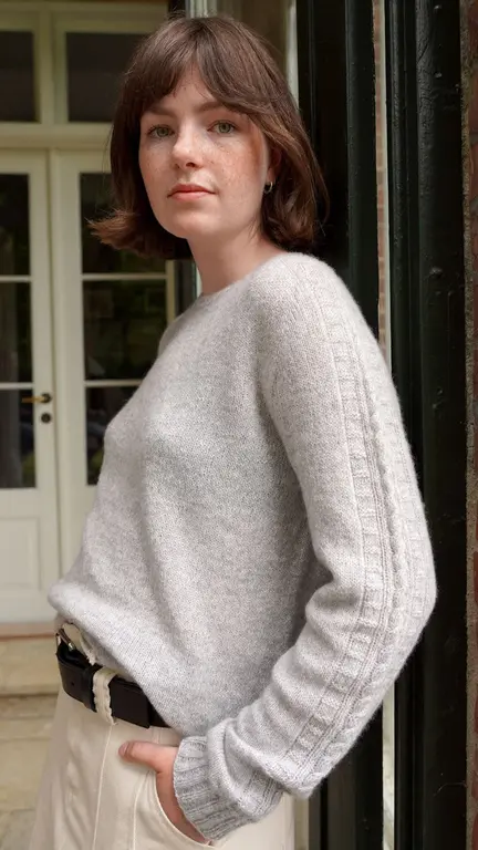 Model iført Strikket Sandoy bluse fra kit couture. Strikket i cashmere farven lys grå garn fra kit couture