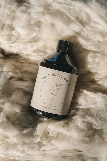 flaske med hjelholt uldsaebe ligger paa uld