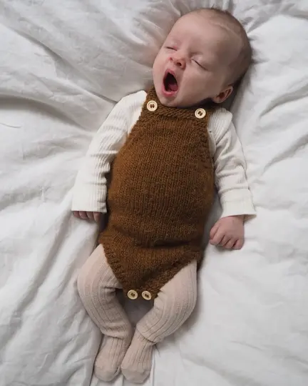 Baby iført Lillebrors Romper strikket i Lamauld fra CaMaRose – brun strikket babyromper med seler