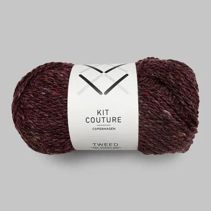 Nøgle af Kit Couture Tweed garn i farven Blomme 516, dyb lilla merinould med fine tweednister.