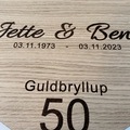 Gravering af navne og dato på guldbryllup æresport hjerte i træ