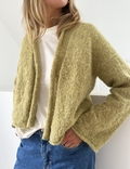 model med haender i lommen staar afslappet hun erifoert plaine cardigan light design leknit