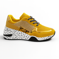 Gul modesneaker med guld detaljer og hvid sål med sorte prikker.