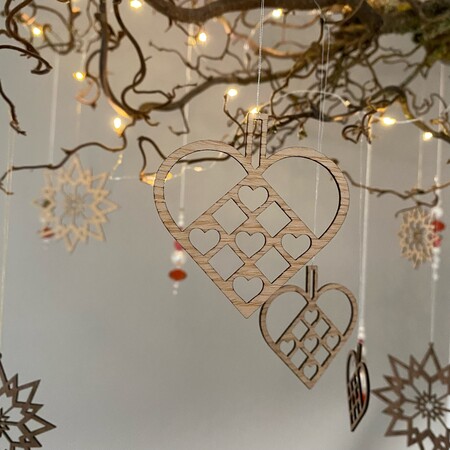 Julehjerte i træ ophængt i gren – dansk julepynt i nordisk stil